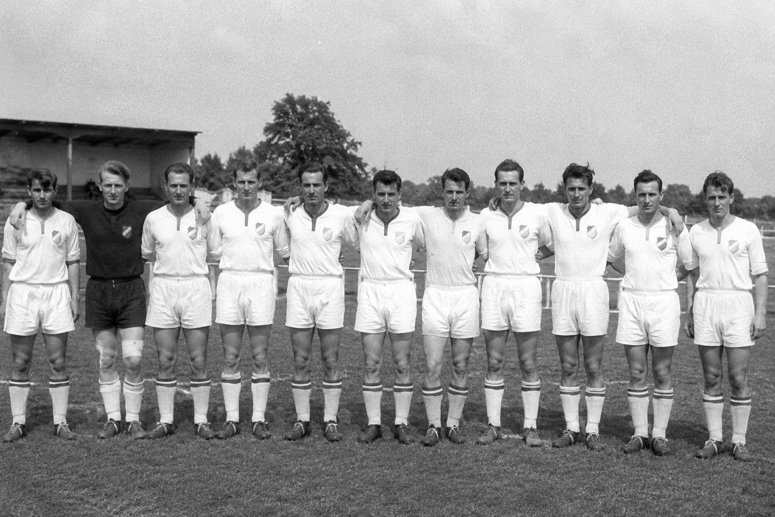 Historisches Mannschaftsfoto des SV Gersweiler, elf Spieler aufgereiht vor der Tribüne